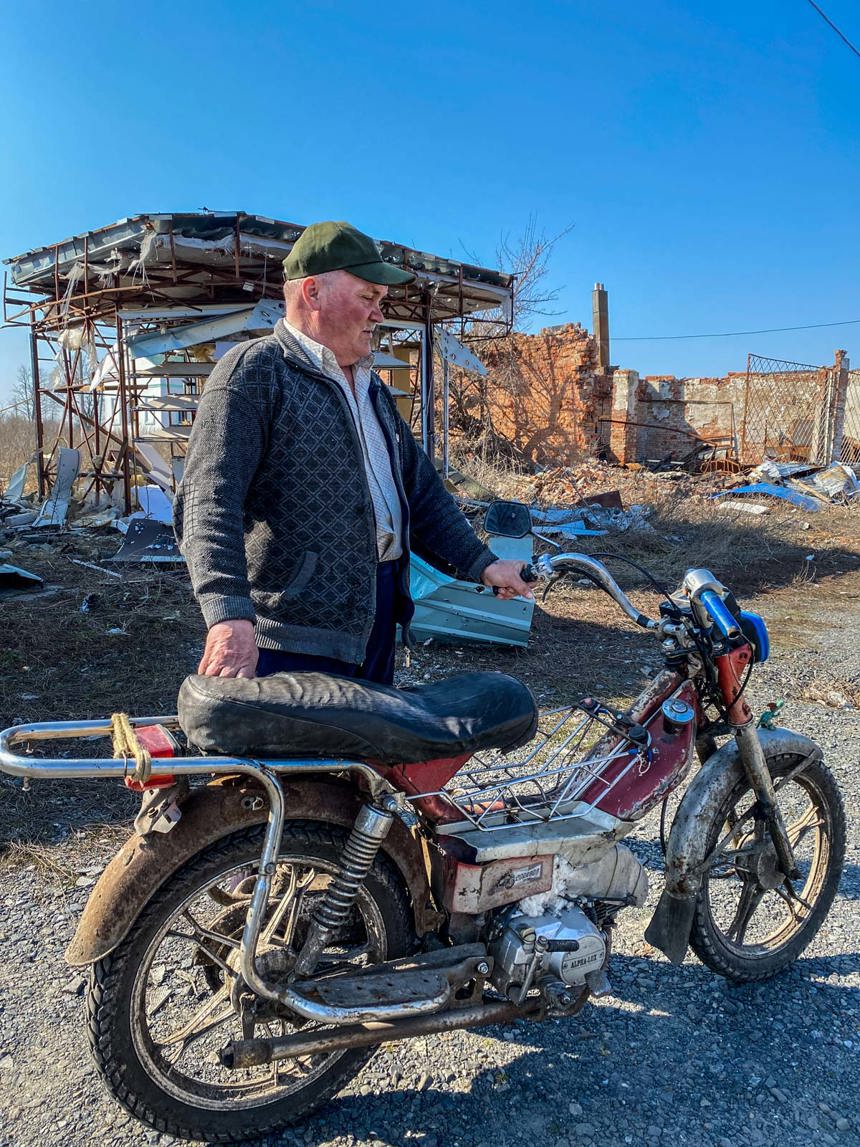 Viktor stands with his motorbike next to scaffolding