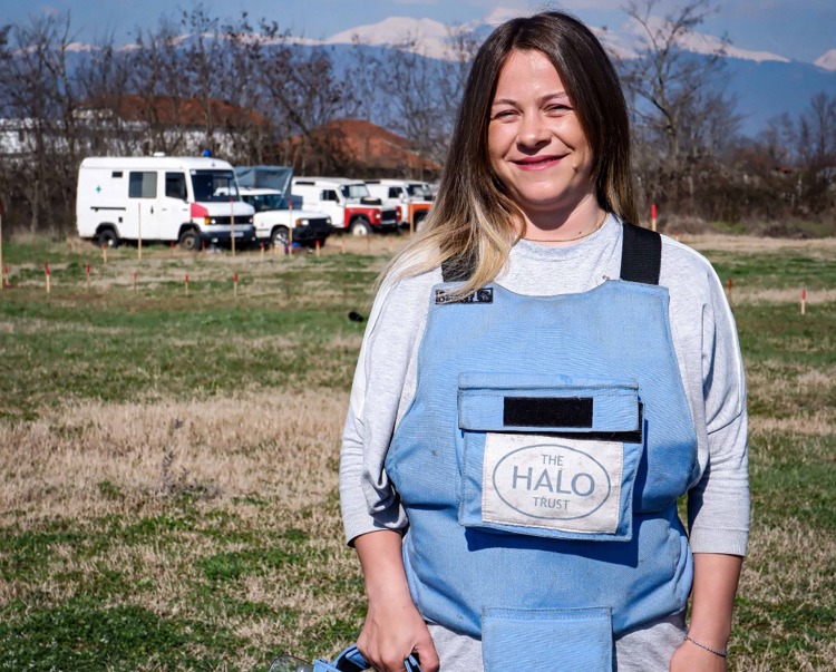 Fjolla Podrimja, a deminer in Kosovo stands in a minefield in PPE