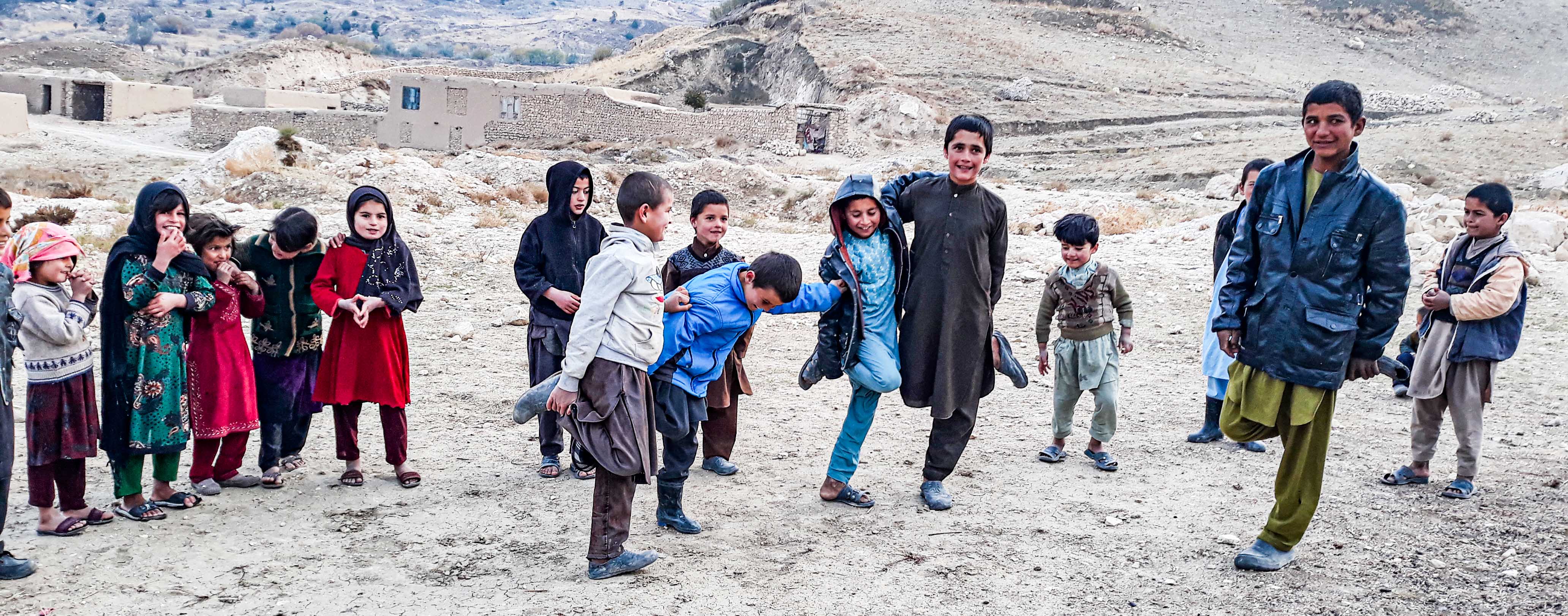 Children stand together smiling in a  district of Samangan province