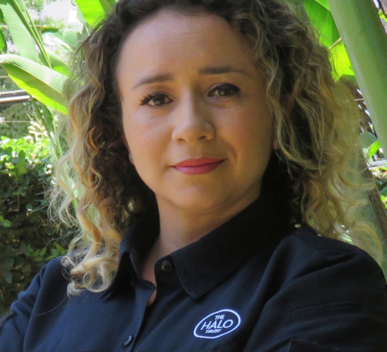 Francy Bolanos, a programme officer in Honduras poses outside a green hedge