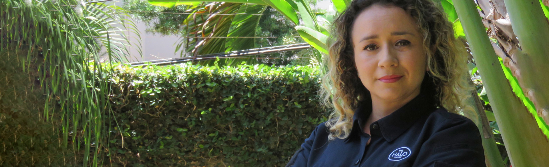Francy Bolanos, a programme officer in Honduras poses outside a green hedge