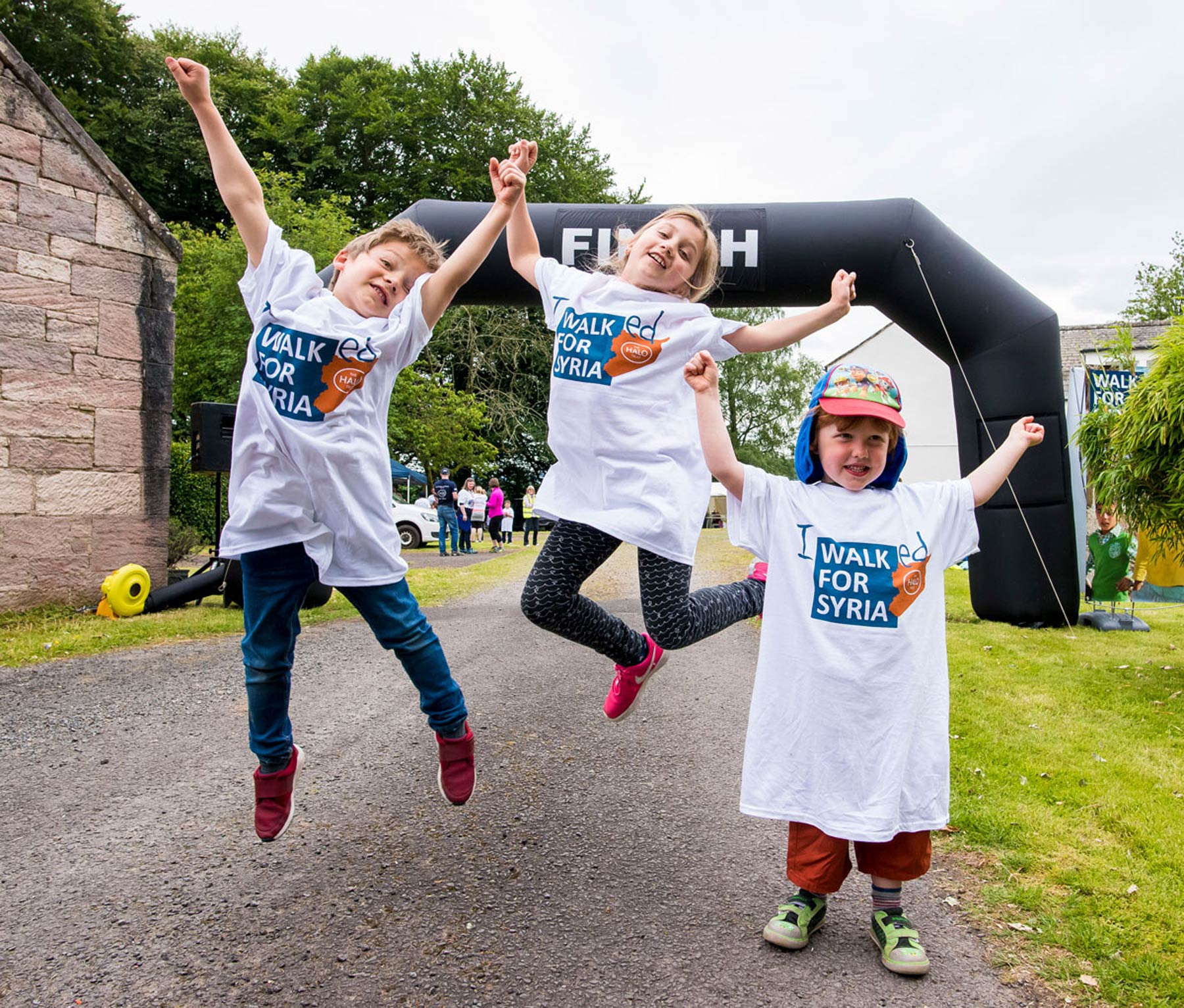 Children jumping at the finish line of a fundraising event for Syria