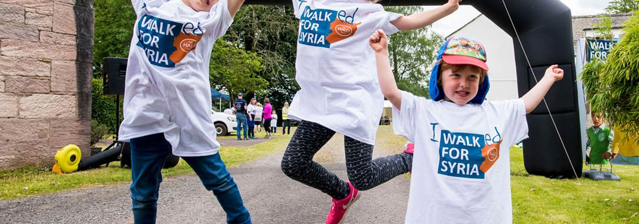 Children jumping at the finish line of a fundraising event for Syria