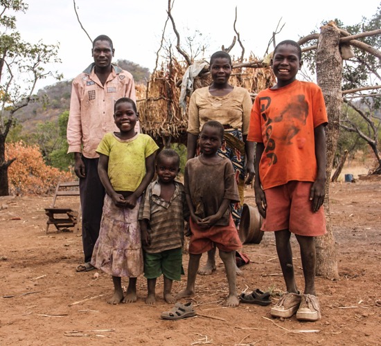 Zimbabwean farmer, Romeo Titus, stands with his family on HALO cleared ground