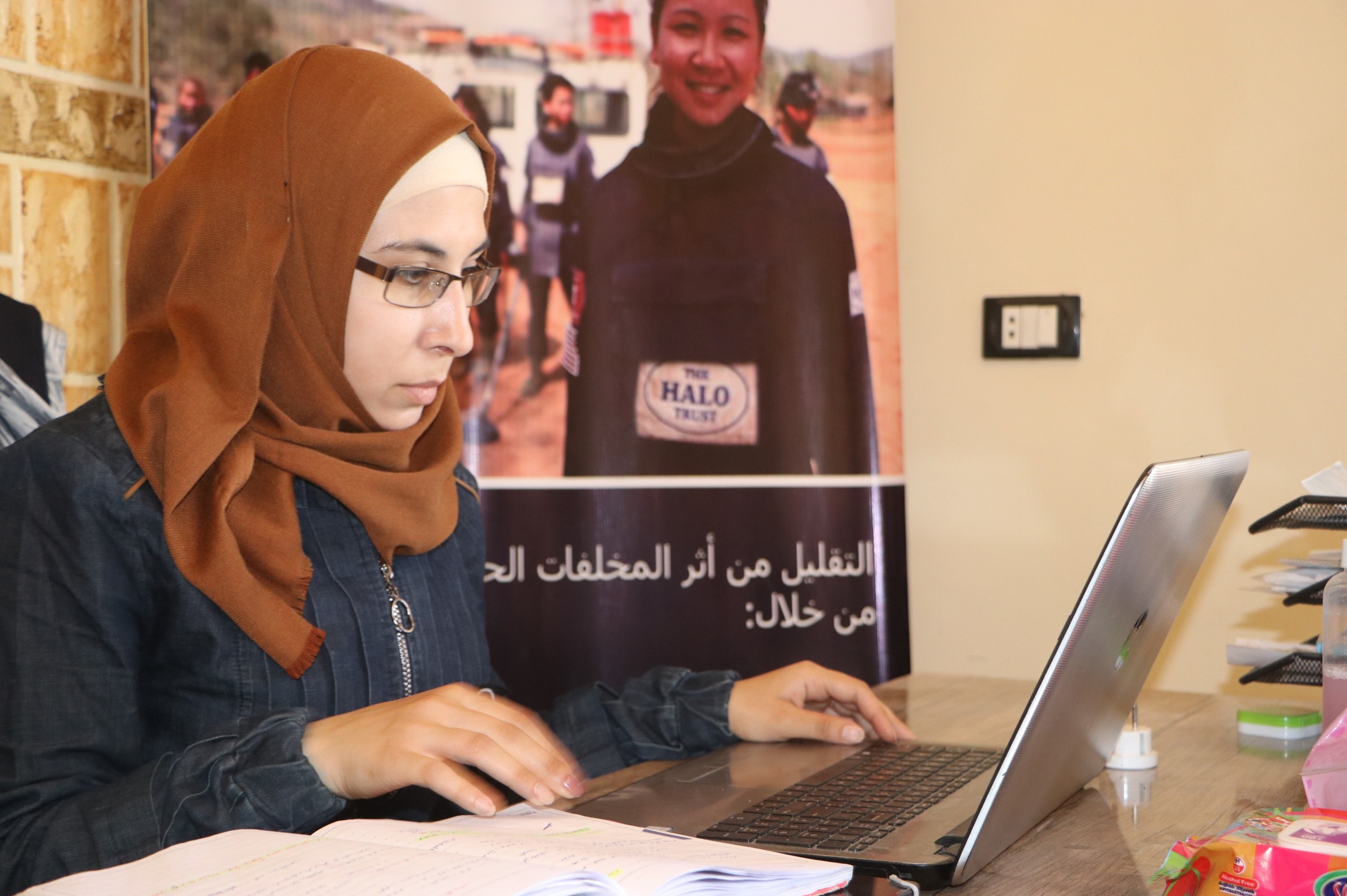 Nour Sheehan, Explosive Accident Support Worker sits in an office