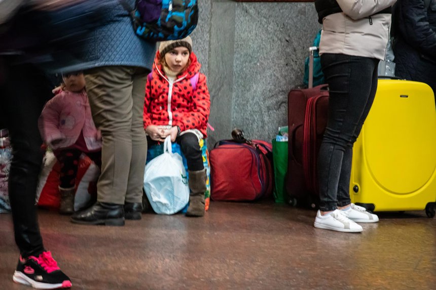 Children sit on luggage in Lviv, Ukraine