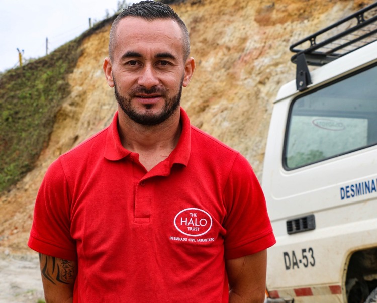 Ovier, a senior supervisor, stands in front of a vehicle in Colombia