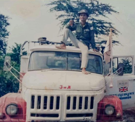 Mr Moeun Samet sits on the roof of a white HALO vehicle