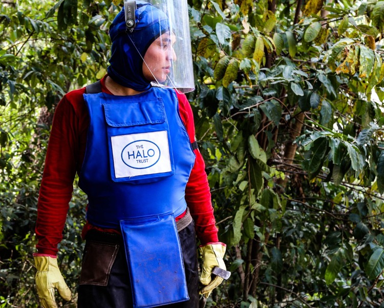 Ronal Pinto, wears PPE and a visor in a dense forest in Colombia