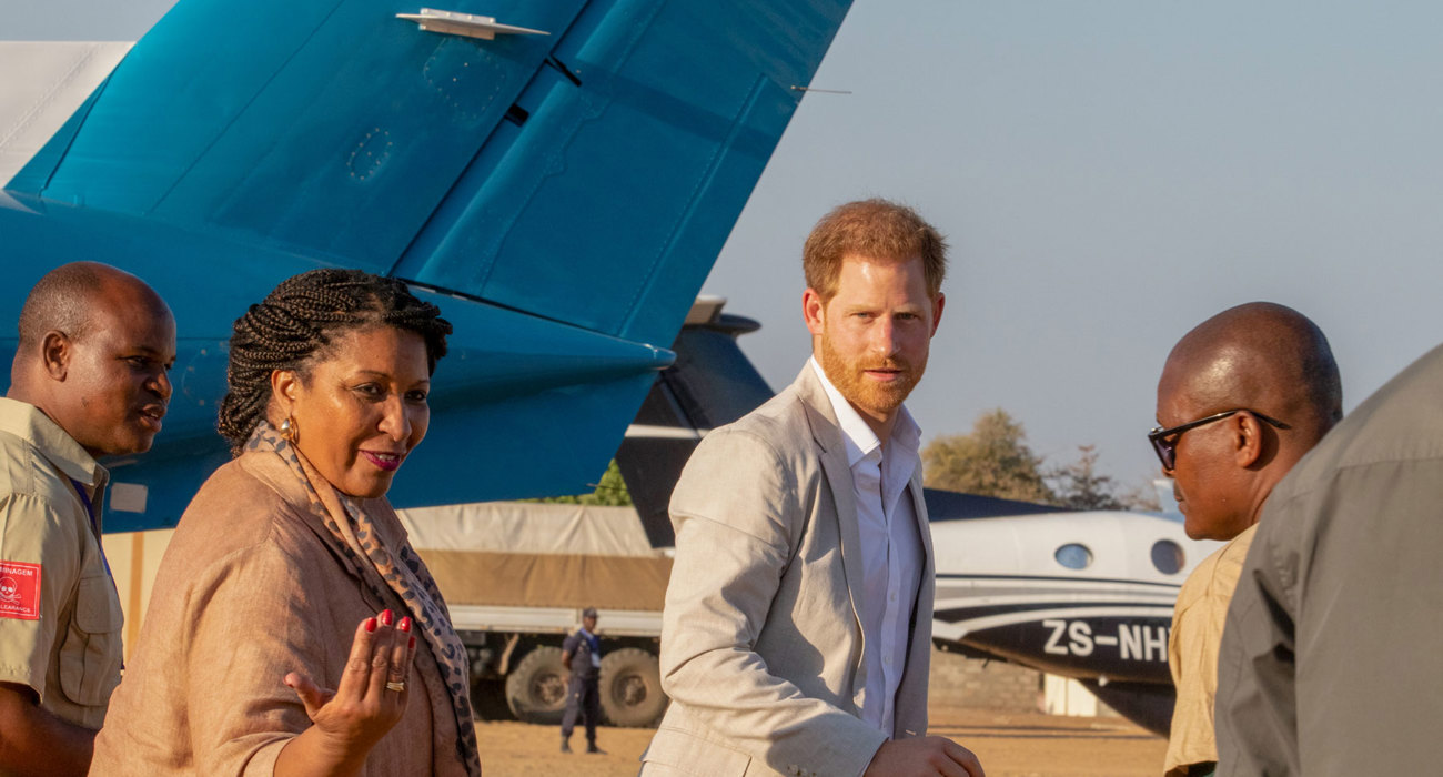 Prince Harry meets HALO Trust Trustee and Angolan Prime Minister next to an aeroplane in Angola