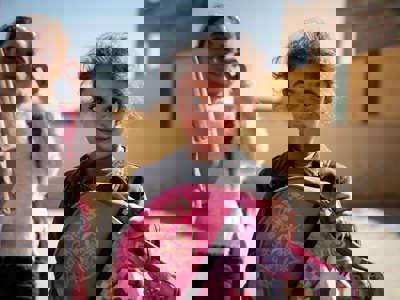 Syrian girl holding a backpack and smiling