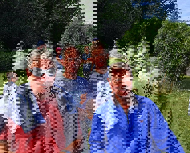 Four men smile and pose on grass with their "walk for Syria" T-shirts