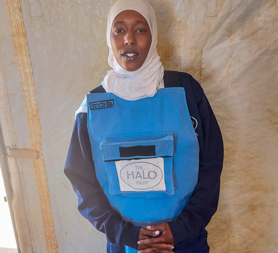Ubah, a female deminer poses in her PPE