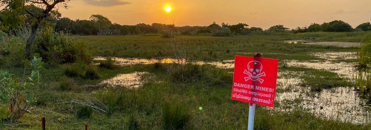 A flooded minefield in Sri Lanka with the sun setting in the background