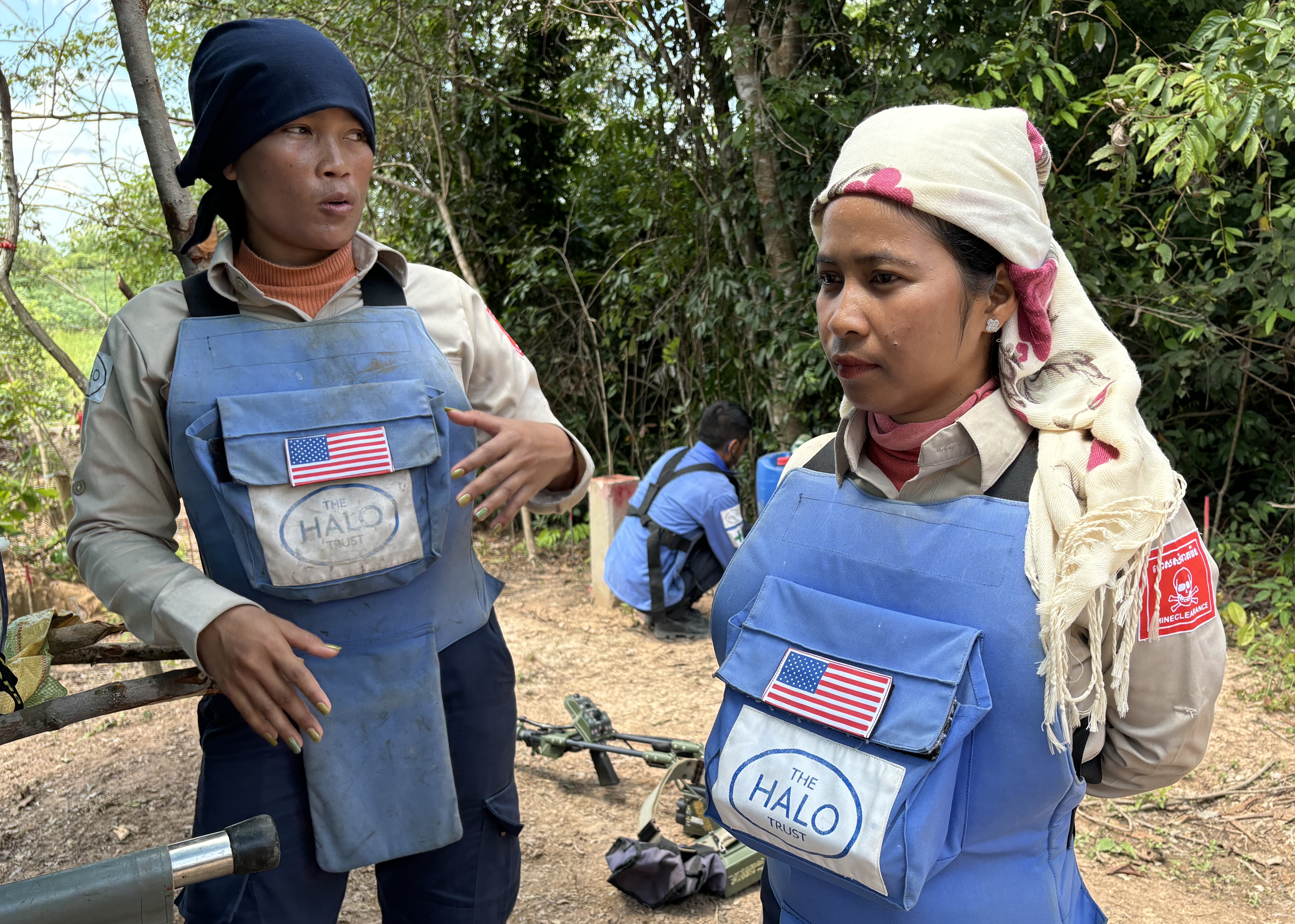 Ly Sreyneang and Pat Liv wear PPE whilst talking together outside