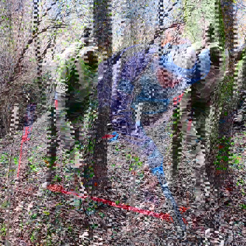 A deminer carefully uses a detector in woodland in Lindava village