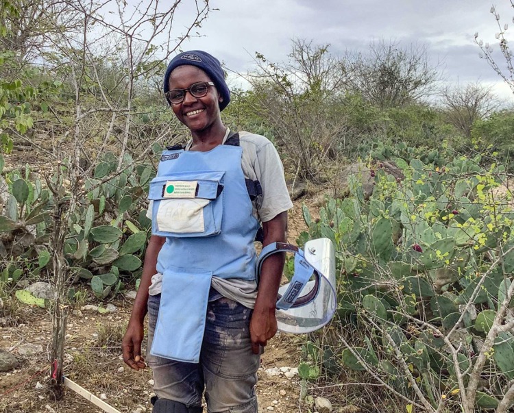 Ana Albino, a female deminer in Angola, wears PPE and holds a visor