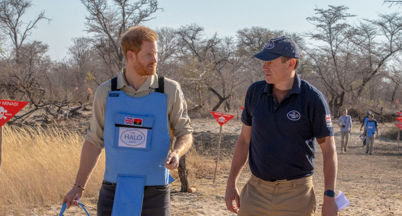 Prince Harry wears a protective vest whilst walking through a minefield with HALO Trust CEO, James Cowan