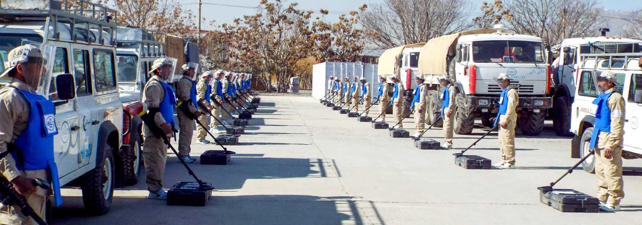 HALO demining teams stand in uniform and PPE holding detectors in the HALO compound in Afghanistan