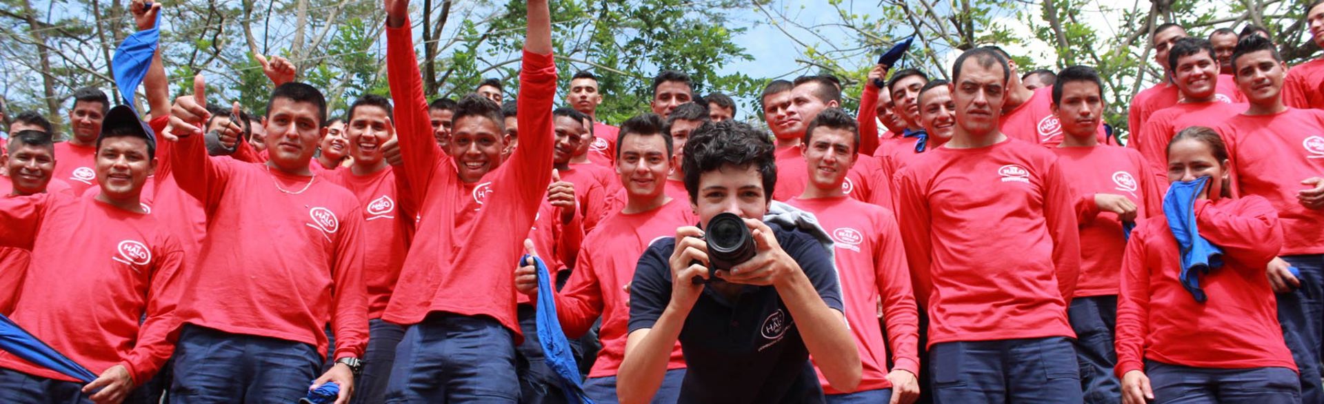 A demining team in Colombia stand behind a photographer holding a camera