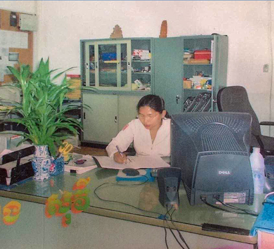 Mrs Seang Sokvy sits behind a desk wearing HALO uniform