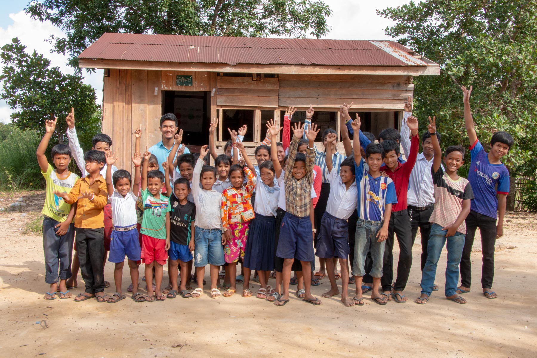 A large group of children waving in Cambodia