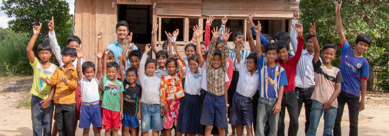 A large group of children waving in Cambodia
