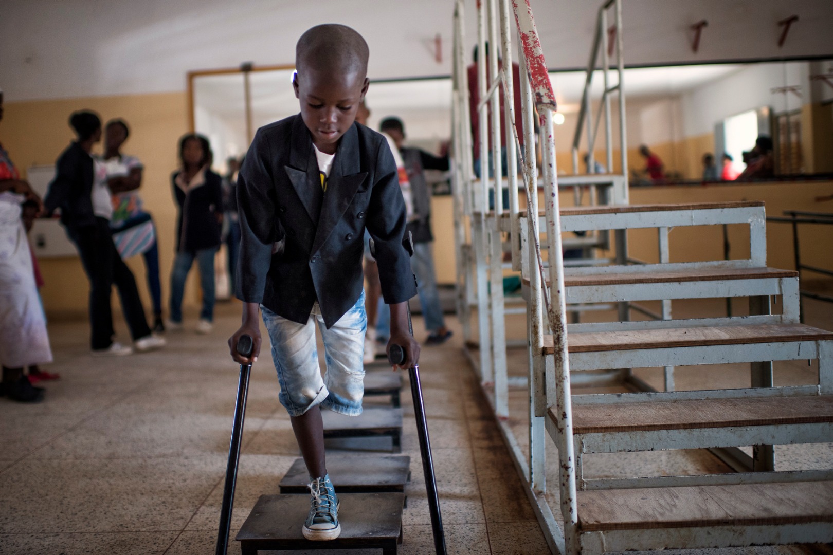 Manuel, learns to walk using steps and crutches in a rehabilitation centre