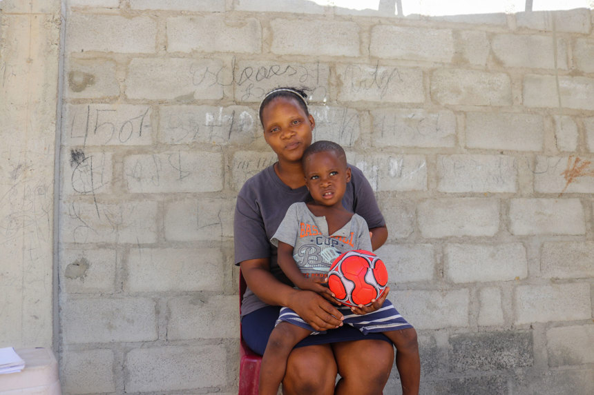 Elisa Sabino sits with her child in Angola