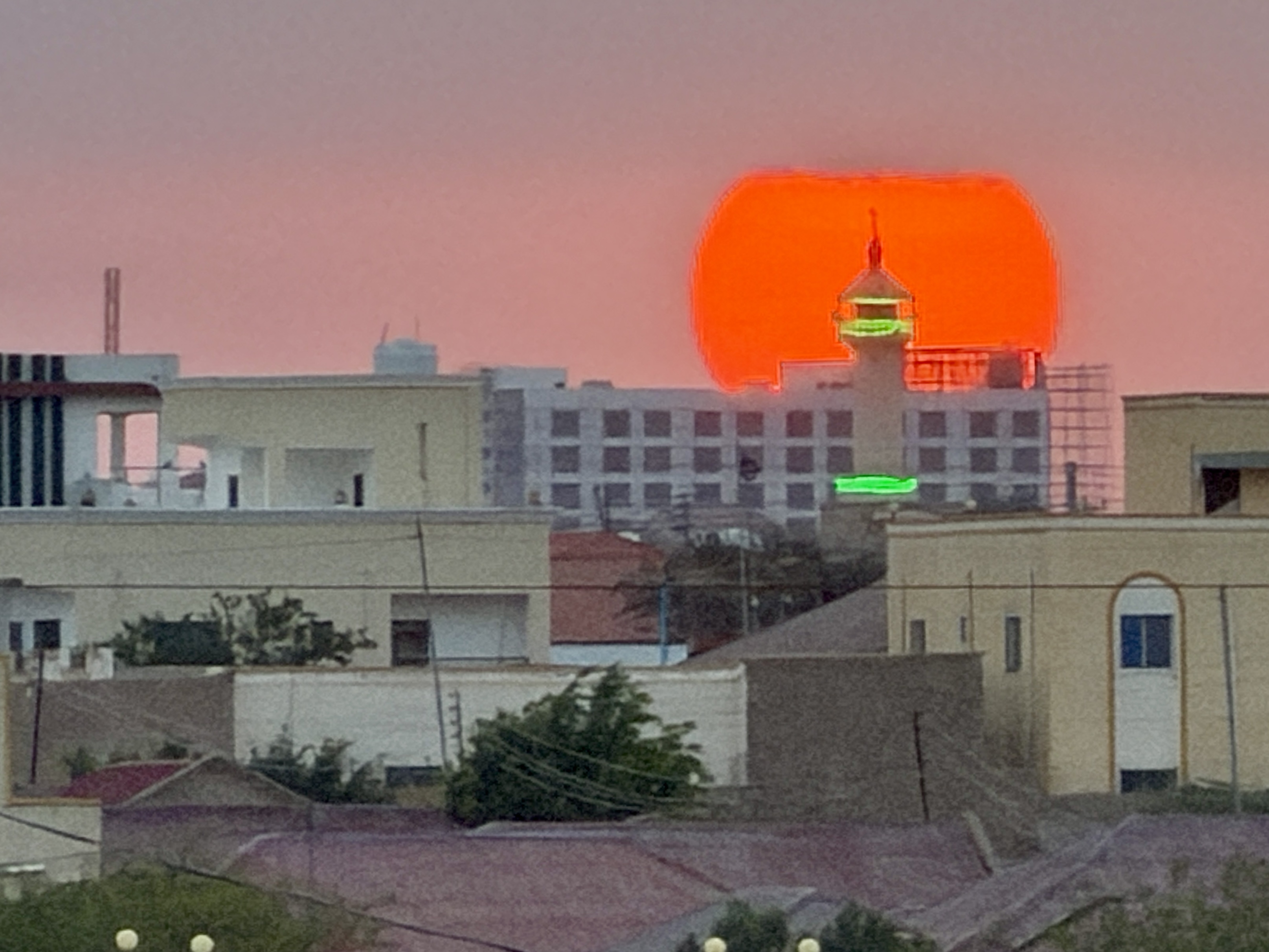 A vivid sunset over several buildings in Somalia