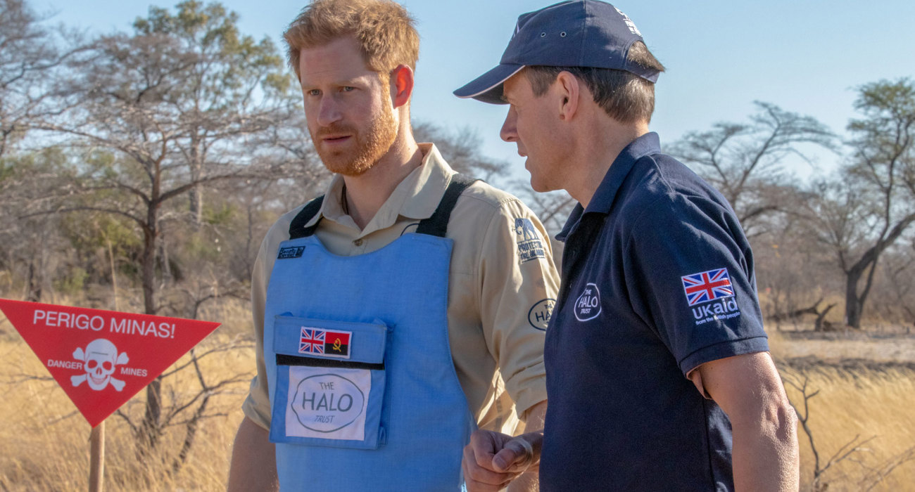 Prince Harry and HALO Trust CEO, James Cowan, walk through a minefield in Angola wearing HALO Trust uniform