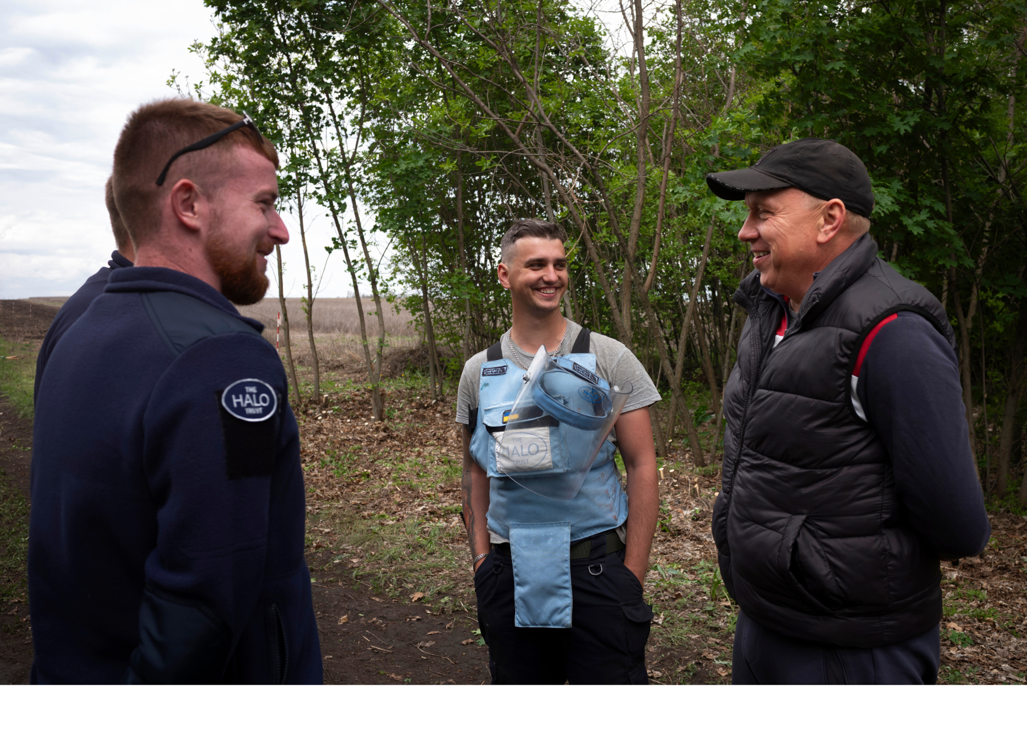 HALO team members smile on a field together in Kharkiv 