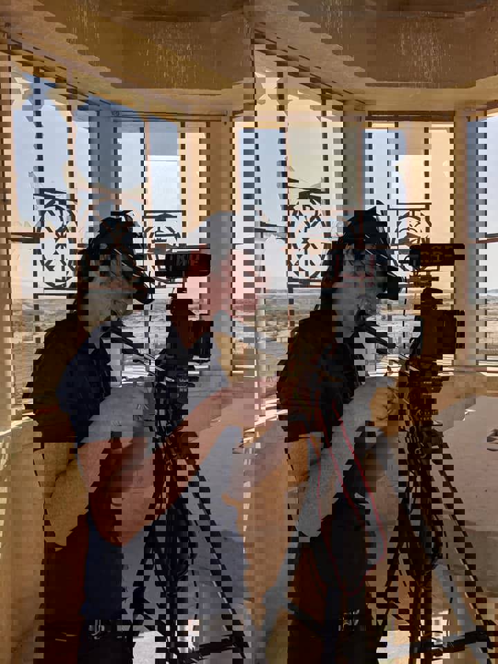 Much loved colleague, Rachel Brock, smiling behind a large TV Camera