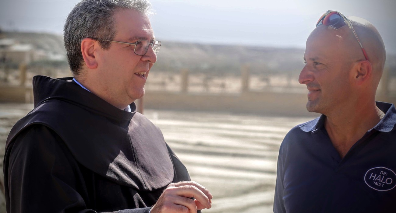 The head of the Franciscan Mission talks with a HALO Trust staff member following the removal of landmines from the compound