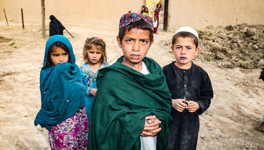 A group of children in Afghanistan stand in front of their home, which was used to store IEDs