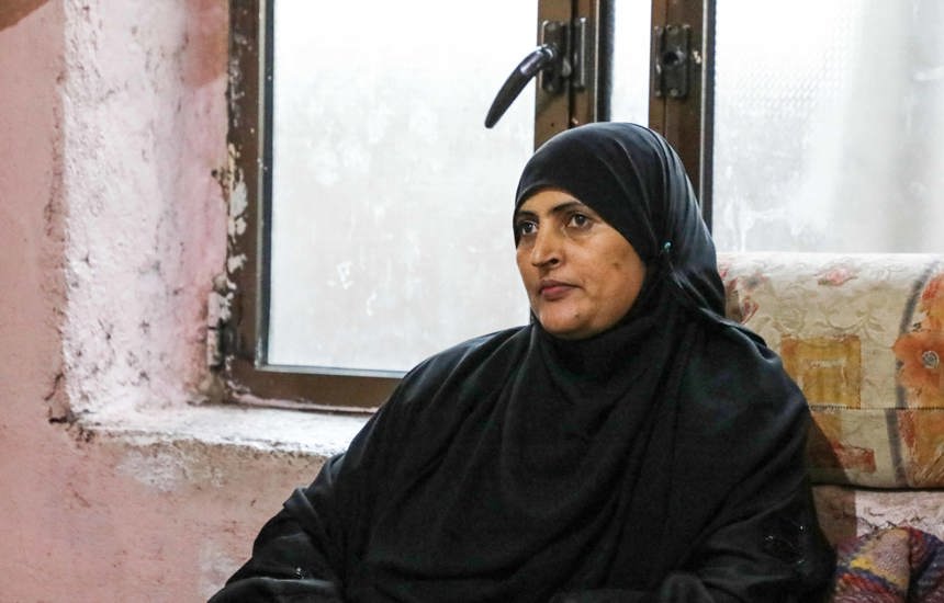 A woman in a hijab sitting in front of a window in a room
