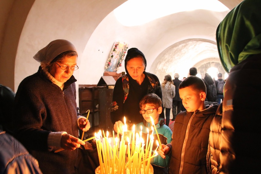 Children and adults gather to light candles at the Baptism Site
