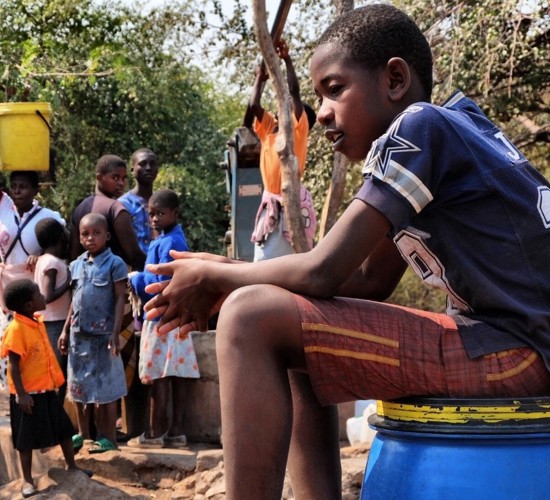 11 year old Maphioss collects water from a borehole in Zimbabwe