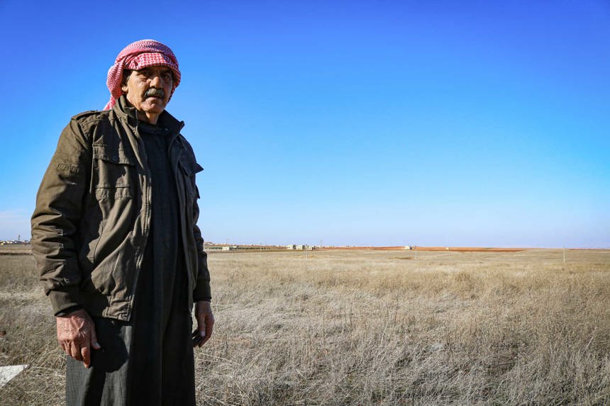 Rami, A Syrian farmer stands Infront of his mined field