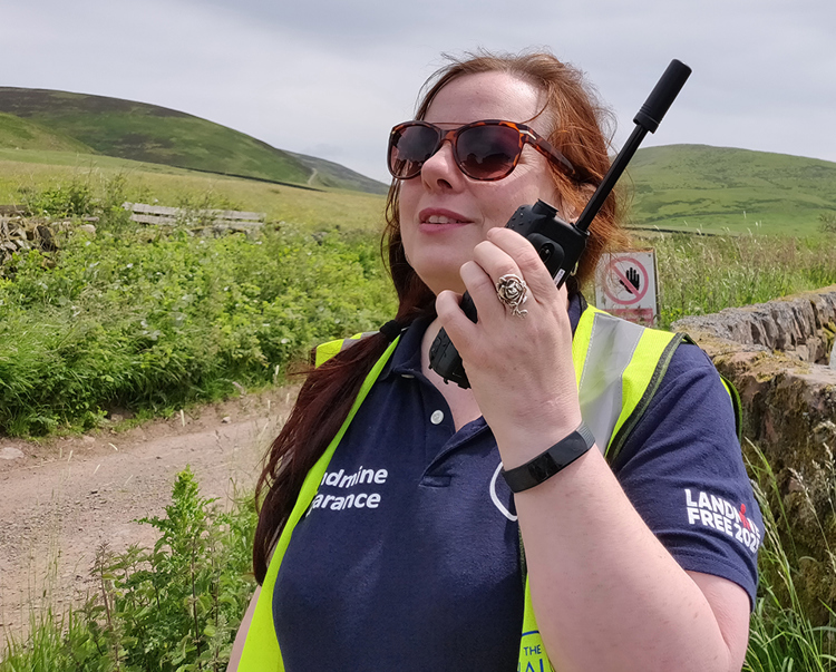A HALO staff members talks into her Iridium PTT handset