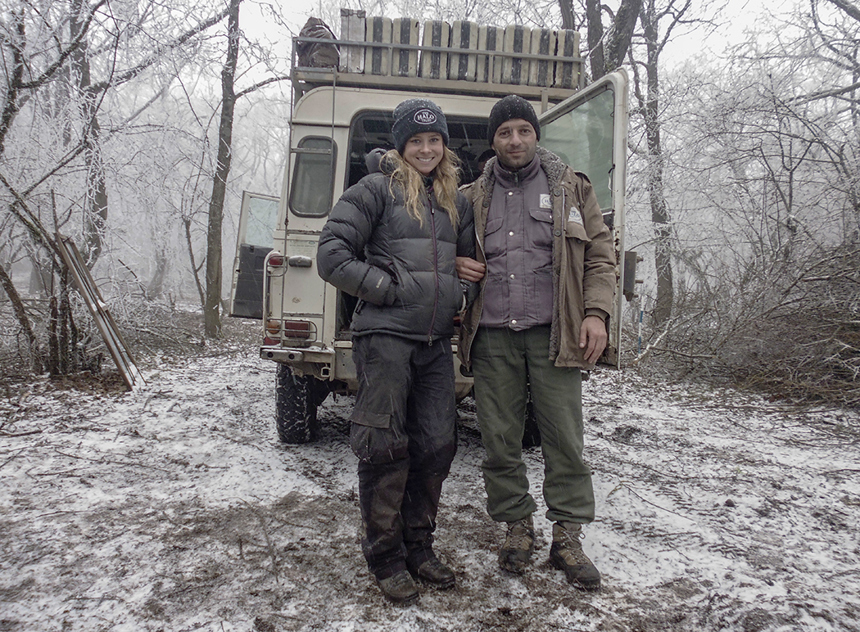 Camilla Thurlow and a fellow HALO Trust Staff member in front of a vehicle on a snow covered road in Nagorno Karabakh